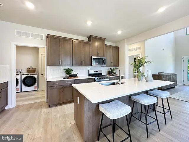 a large kitchen with kitchen island a dining table and chairs