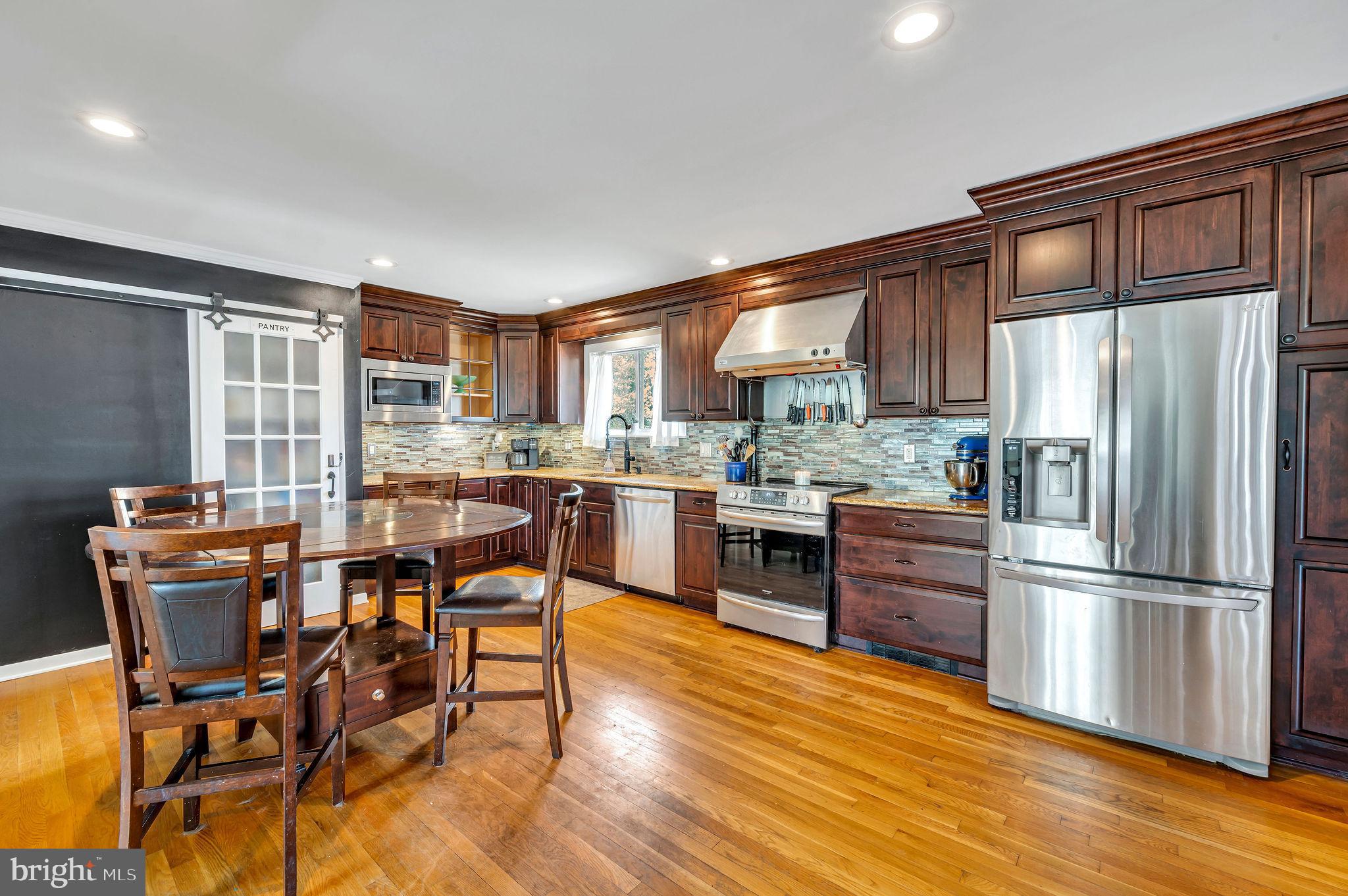 2707 Broder Street Southwest Allentown, PA 18103 - Photo 7 of 32 a kitchen with stainless steel appliances wooden floors and wooden cabinets