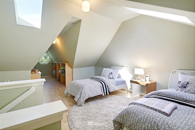 a bedroom with two beds and painting on the wall