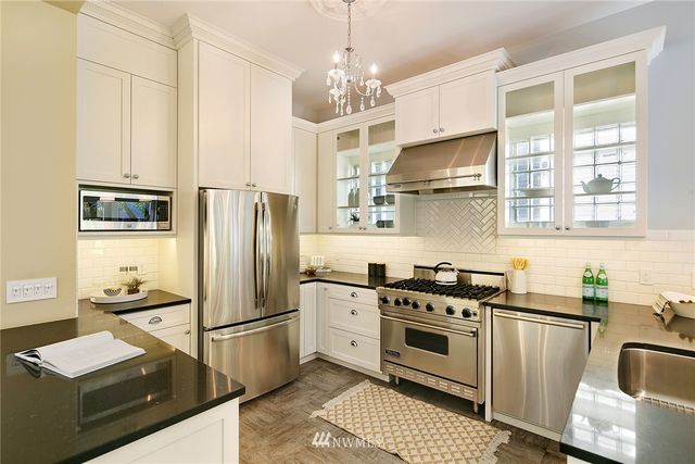 a kitchen with stainless steel appliances granite countertop a stove a refrigerator and a sink