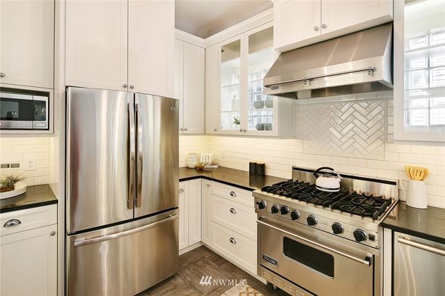 a kitchen with stainless steel appliances granite countertop a refrigerator sink stove and refrigerator