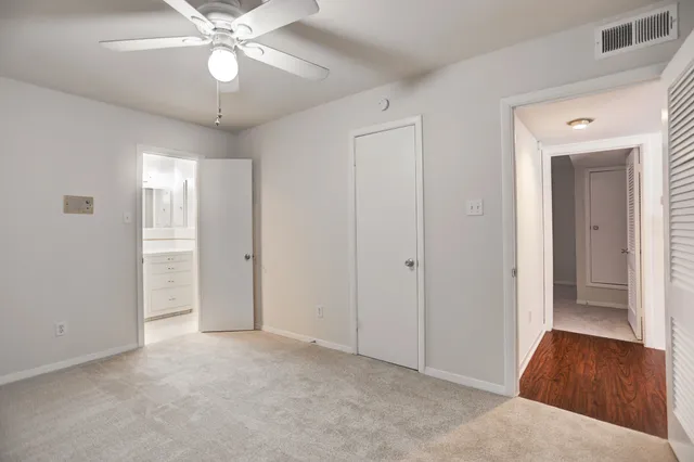 a view of an empty room with a chandelier fan