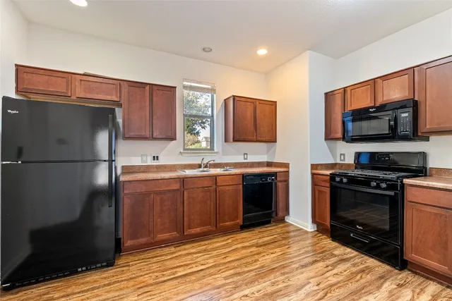 a kitchen with stainless steel appliances granite countertop a refrigerator stove and microwave