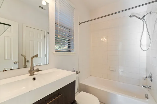 a bathroom with a sink double vanity mirror and a bathtub