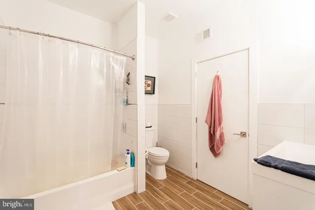 a bathroom with a shower curtain and a toilet