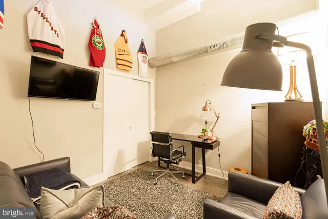 a view of a workspace with furniture and a flat screen tv