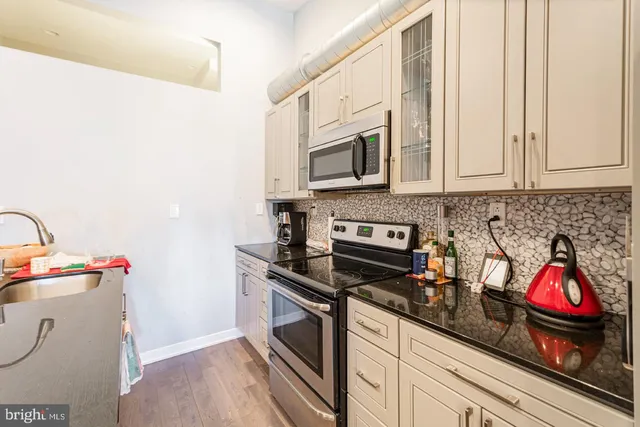 a kitchen with stainless steel appliances granite countertop a stove and a microwave