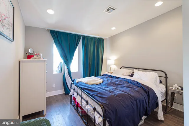 a bedroom with bed and wooden floor