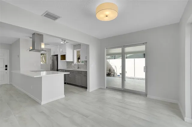 a kitchen with white cabinets and window