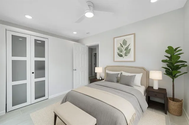 a bedroom with a bed and a potted plant