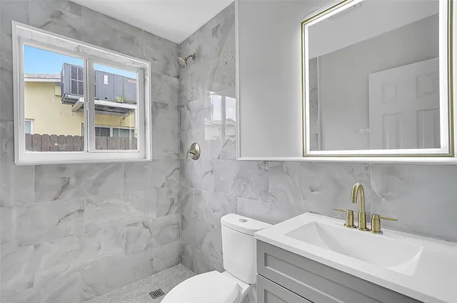 a bathroom with a sink a toilet and a mirror