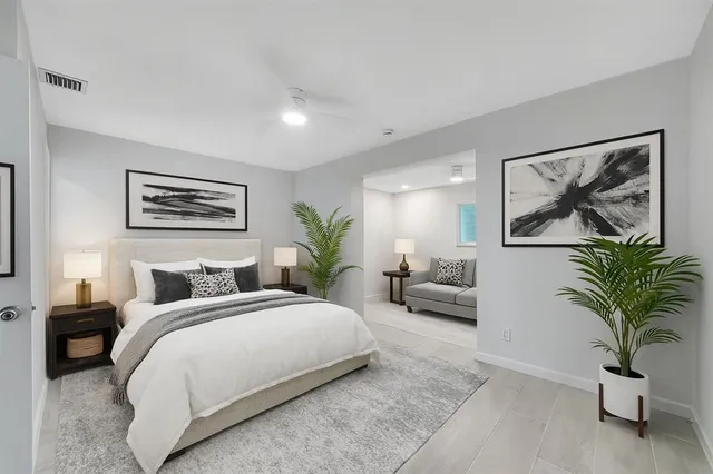 a bedroom with a bed and a painting on the wall