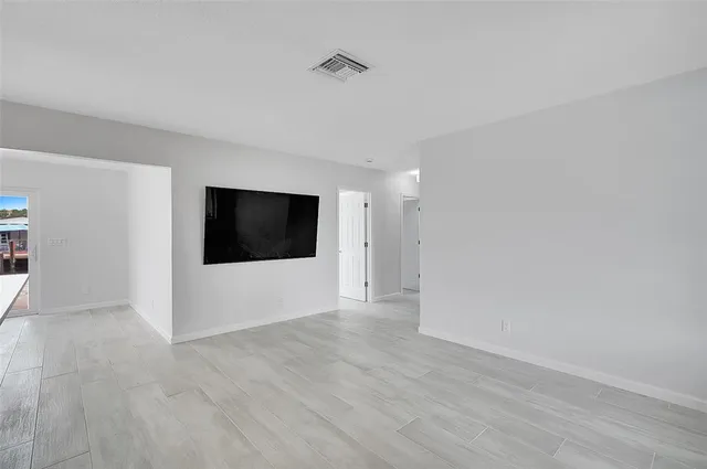 a view of a livingroom with wooden floor and a flat screen tv