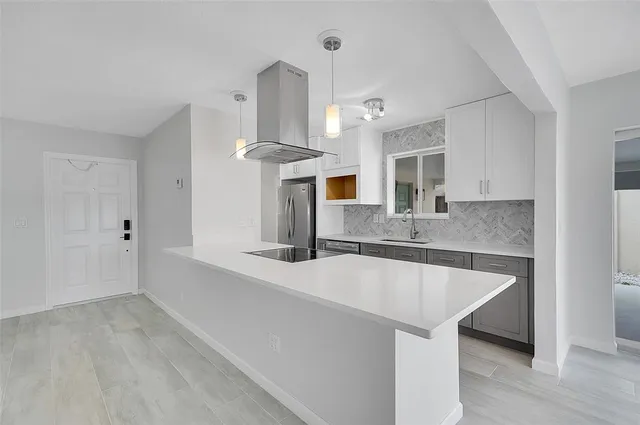 a large kitchen with granite countertop a sink and a refrigerator