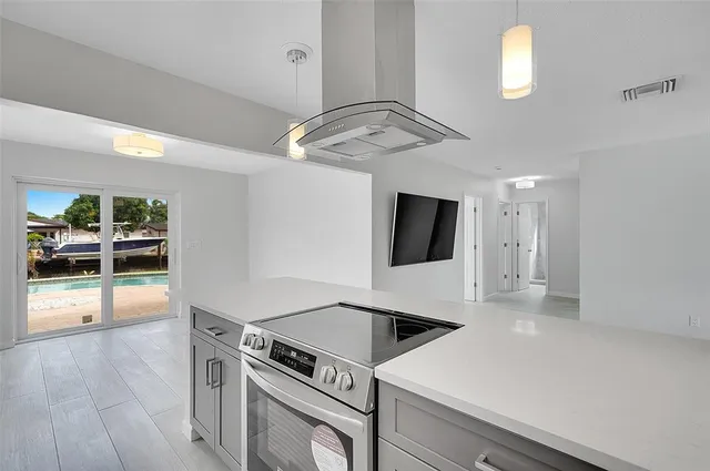 a kitchen with a sink a stove and chairs