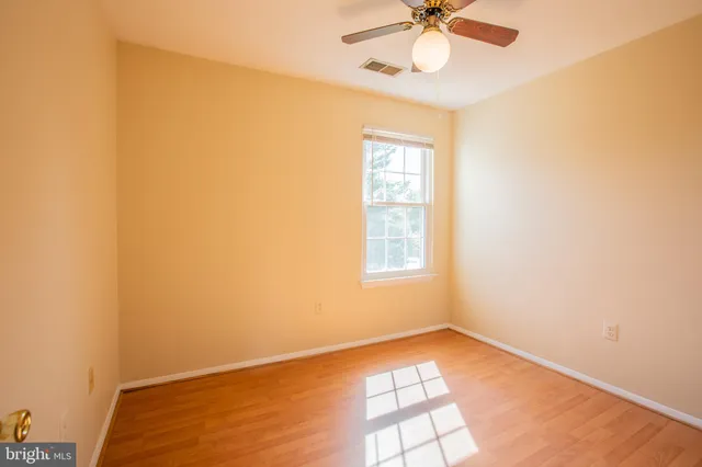 a view of a room with wooden floor and a ceiling fan