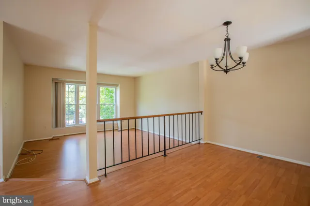 a view of hallway with wooden floor and chandelier