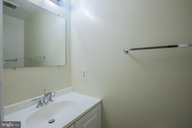 a bathroom with a sink toilet vanity mirror and shower