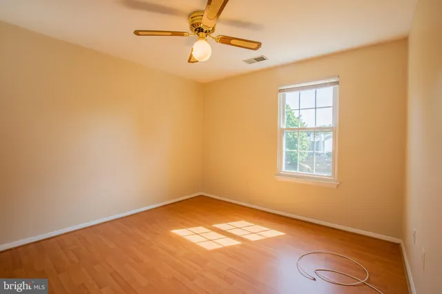 a view of an empty room with closet and a window