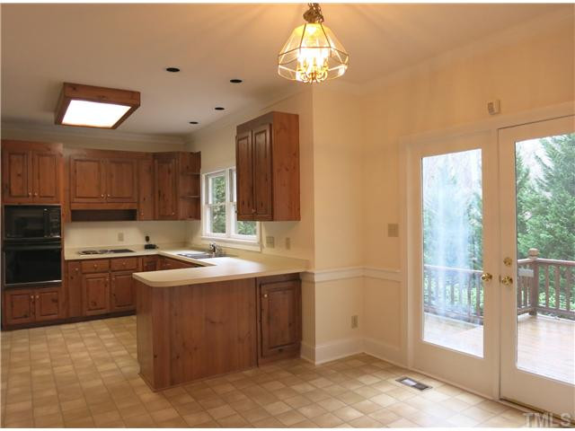 10012 Old Warden Road Raleigh, NC 27615 - Photo 9 of 25 The spacious eat-in Kitchen features lots of wood cabinets, recessed lights, WI pantry, pantry cabinet, dbl wall ovens (including convection/MW on top) and downdraft electric cooktop w/grill & DW. Kitchen
