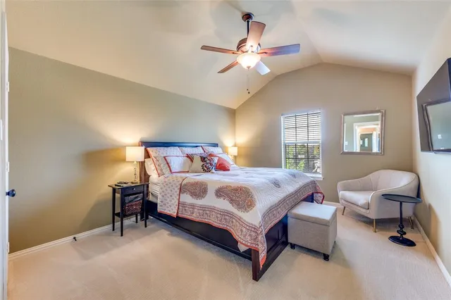 a bedroom with a bed a chandelier and dresser