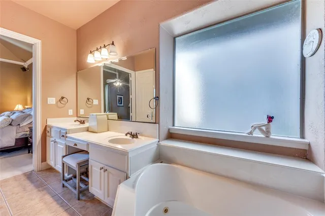 a bathroom with a tub sink and mirror