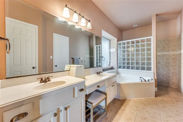 a spacious bathroom with a tub double sink and mirror