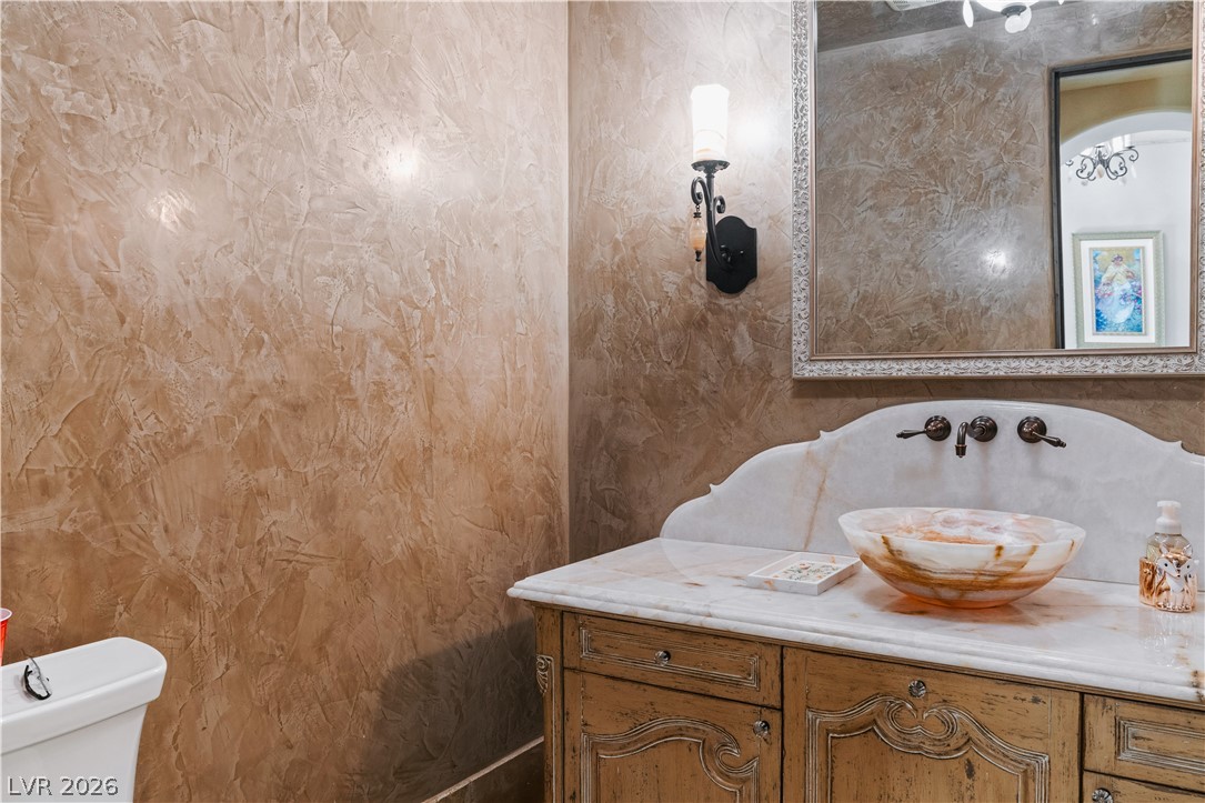 1123 Christian Road Henderson, NV 89002 - Photo 36 of 94 Richly textured walls envelop this bathroom, featuring a unique vessel sink atop a finely crafted vanity.