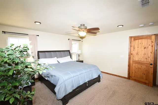 a bedroom with a bed chandelier and a window