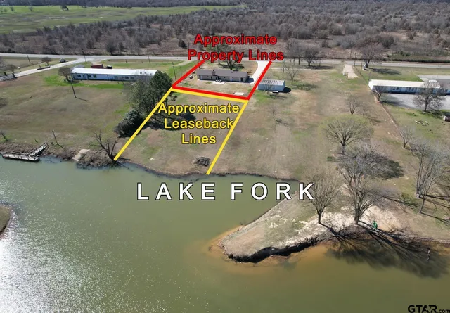a view of swimming pool with seating area and trees in the background