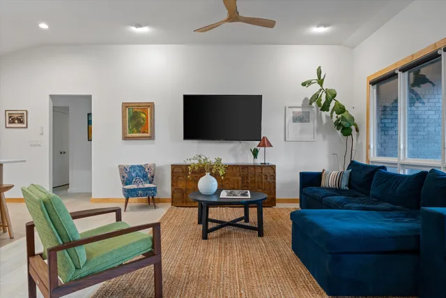 a living room with furniture plant and a window