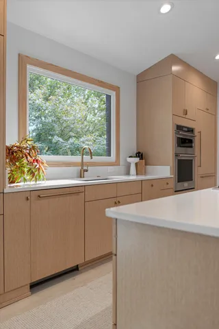 a kitchen with granite countertop a sink stove and cabinets