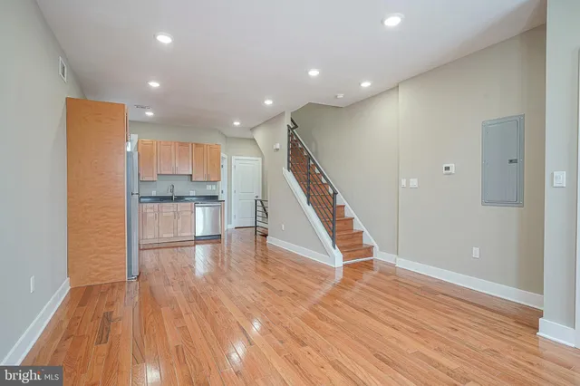 a view of a kitchen with wooden floor and electronic appliances