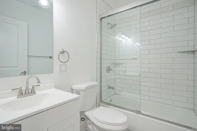 a bathroom with a toilet a sink a mirror and shower