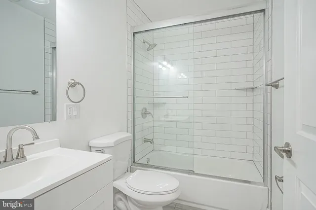 a bathroom with a shower a sink a toilet and a mirror