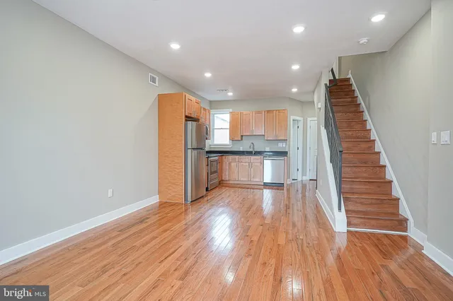 a view of a kitchen with wooden floor and electronic appliances