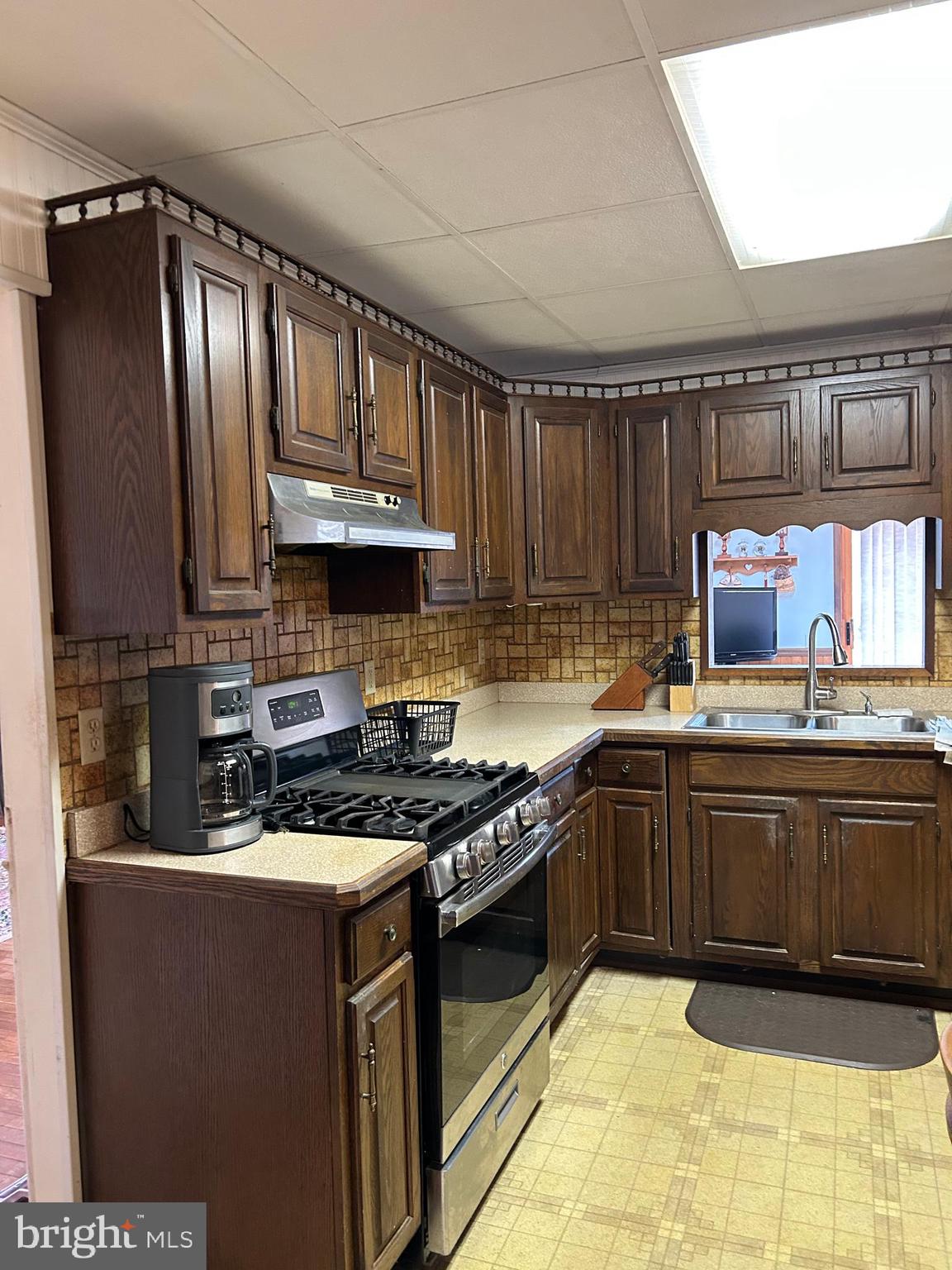 124 Karl Drive Dover, DE 19901 - Photo 39 of 58 a kitchen with granite countertop a stove a sink dishwasher and cabinets with wooden floor