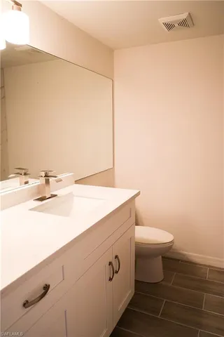 a bathroom with a sink a toilet and mirror