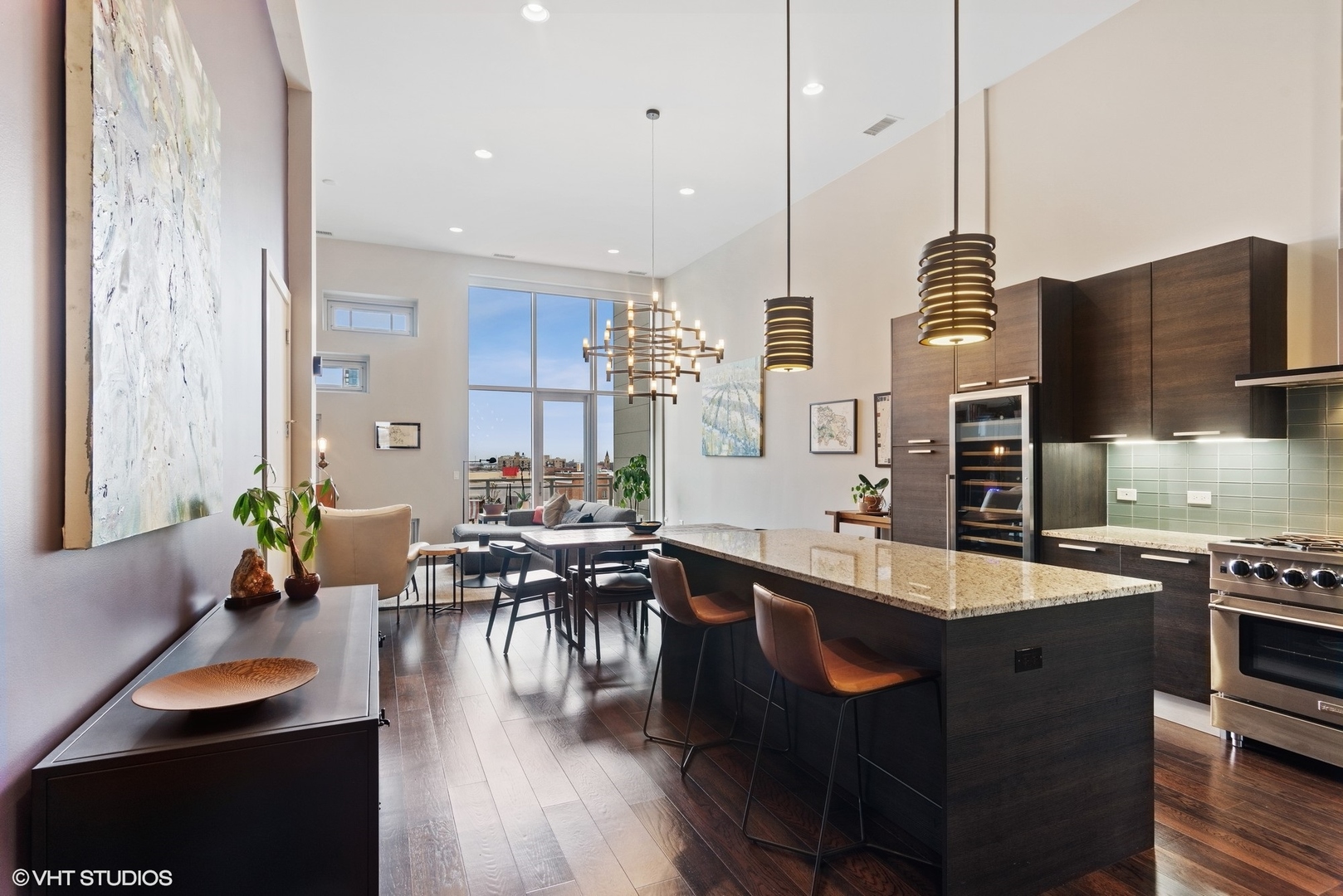 1116 West Adams Street, Unit PHW Chicago, IL 60607 - Photo 2 of 18 a kitchen with stainless steel appliances granite countertop a sink a stove and a wooden floor