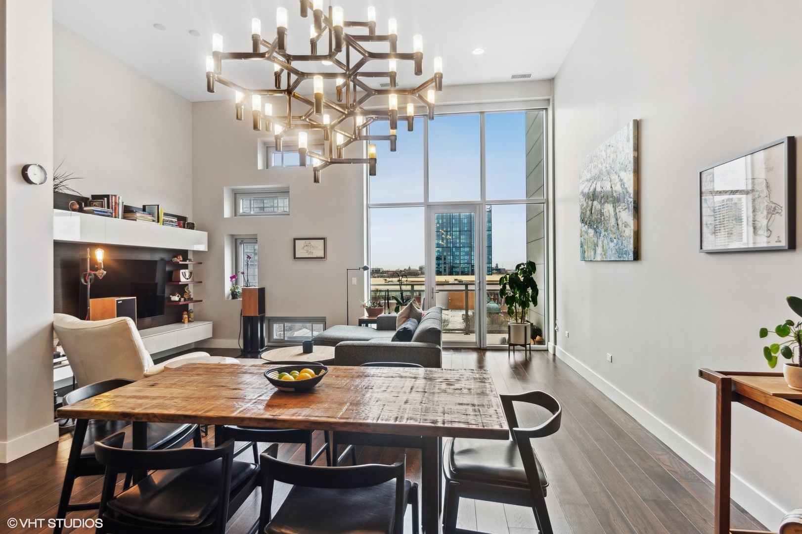 1116 West Adams Street, Unit PHW Chicago, IL 60607 - Photo 3 of 18 a view of a dining room with furniture a chandelier and wooden floor