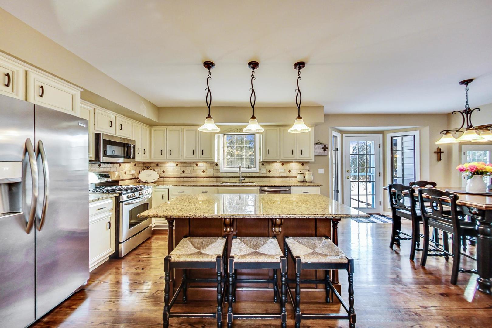 2616 High Meadow Road Naperville, IL 60564 - Photo 5 of 47 a kitchen with stainless steel appliances kitchen island granite countertop a kitchen island and chairs in it