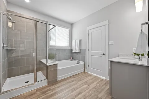 a spacious bathroom with a tub sink and shower