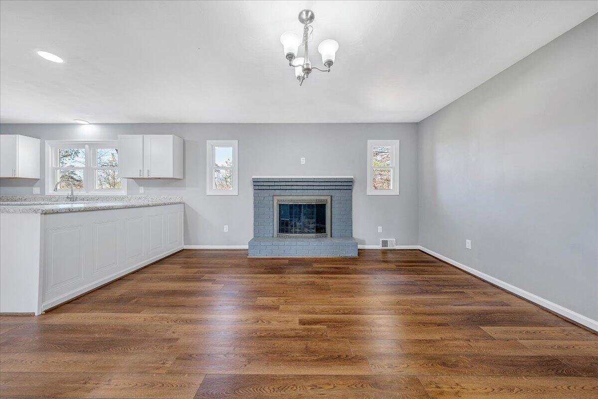 2353 Thompson Ridge Road Ferrum, VA 24088 - Photo 28 of 46 a view of an empty room with a kitchen and fireplace