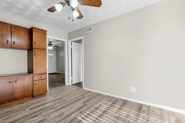 wooden floor in an empty room with a kitchen