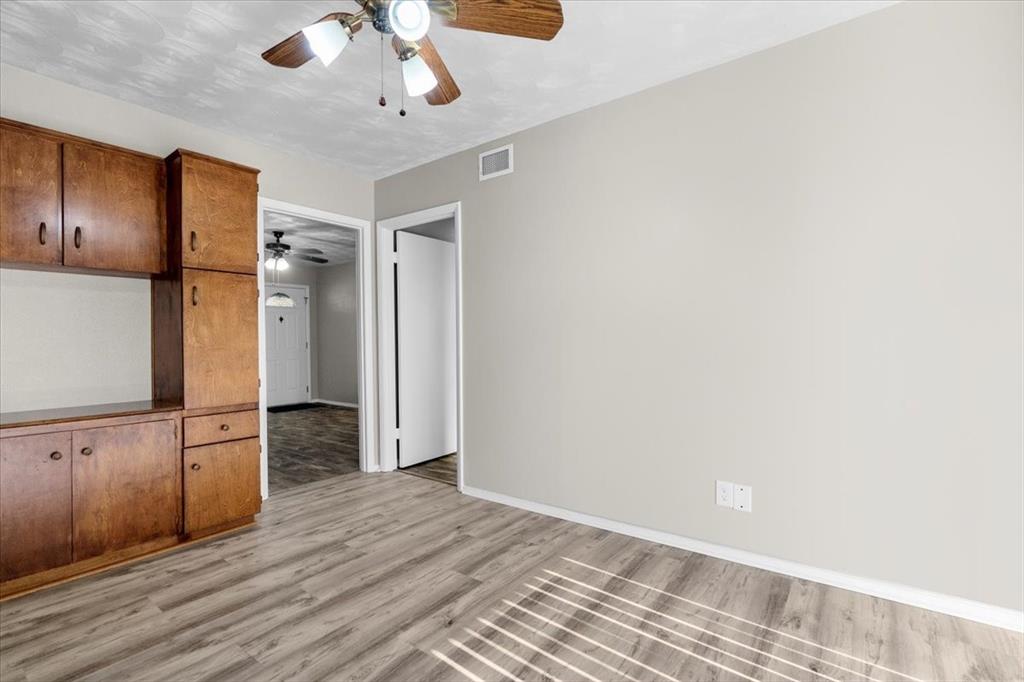 1251 Donna Drive Richardson, TX 75080 - Photo 11 of 39 wooden floor in an empty room with a kitchen