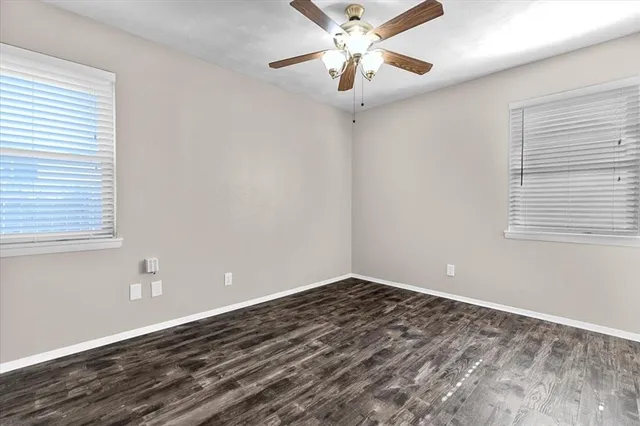 a view of a room with wooden floor and a ceiling fan