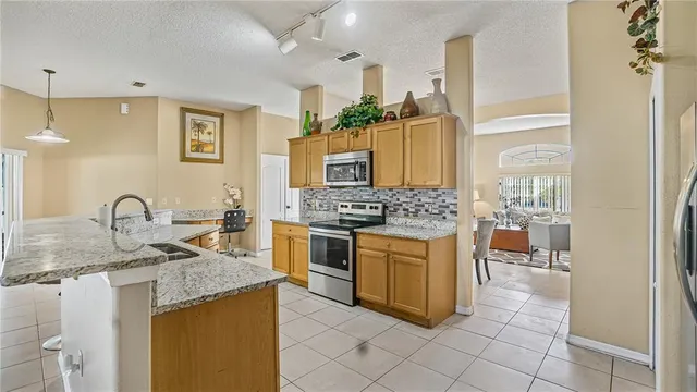 a kitchen with stainless steel appliances granite countertop a sink stove and cabinets