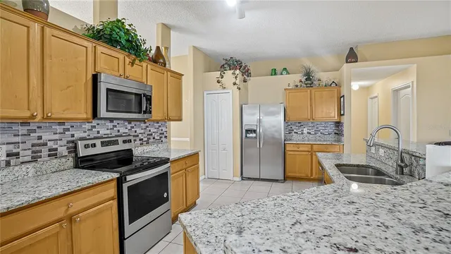 a kitchen with stainless steel appliances granite countertop a stove a sink and a microwave