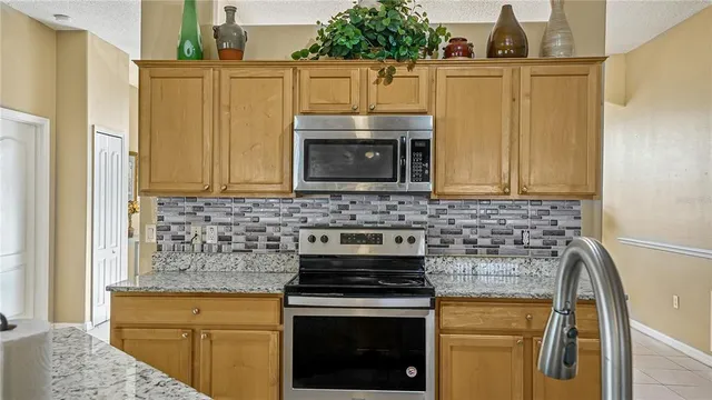 a kitchen with stainless steel appliances granite countertop a stove a sink and a microwave