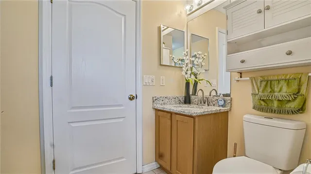 a bathroom with a granite countertop sink and a toilet